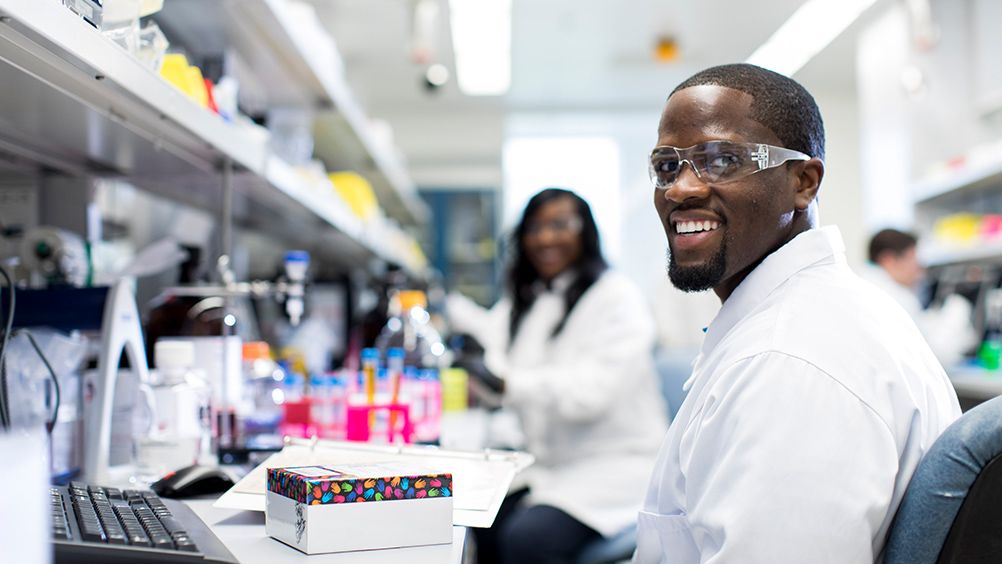 Two scientists in a laboratory smiling