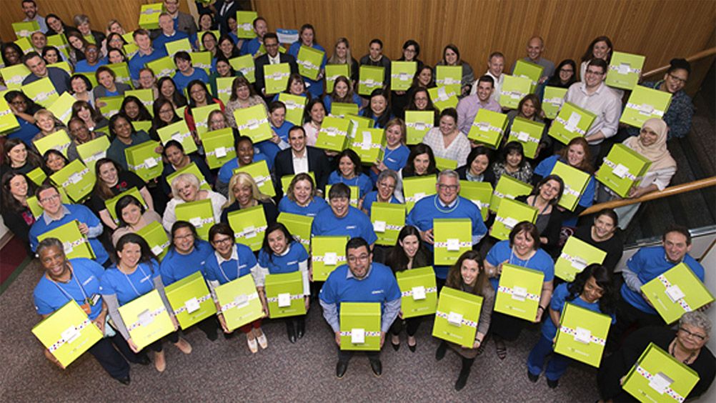 Pfizer employees holding boxes