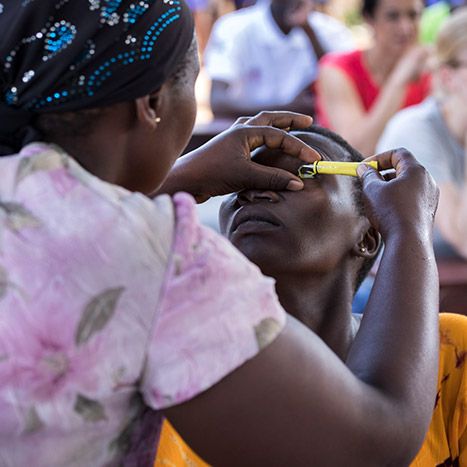 A lady administering eye drops