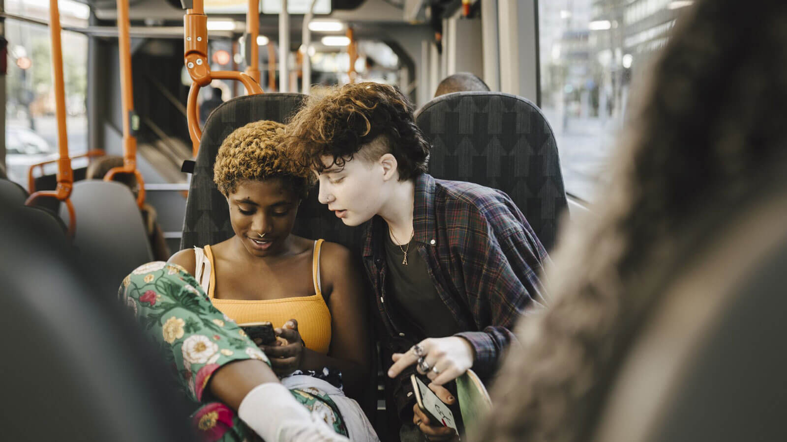 Teens on a bus looking at smartphone
