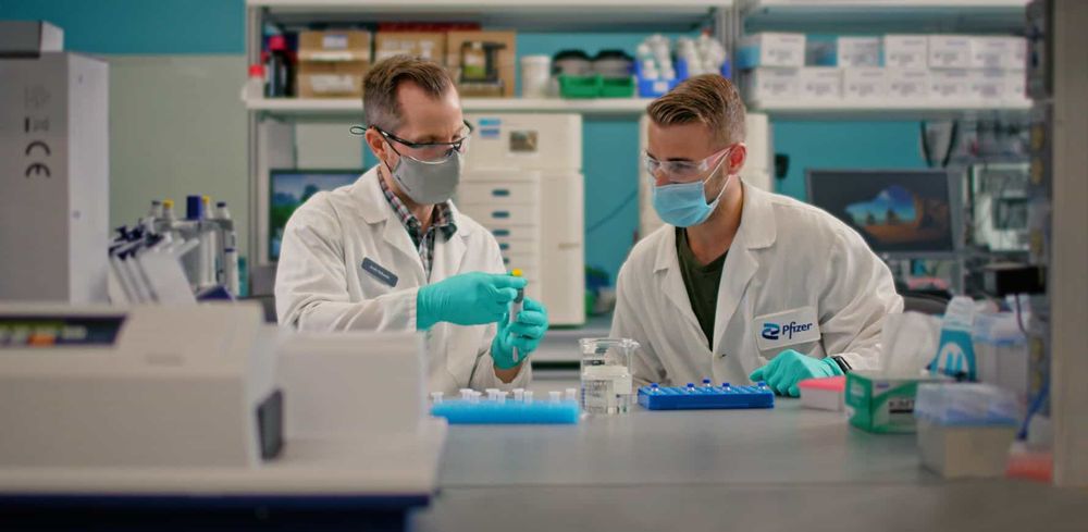 Two male scientists filling vials in a lab