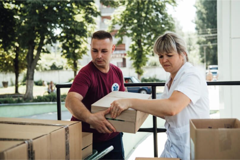 Man and woman unloading truck of Pfizer supplies