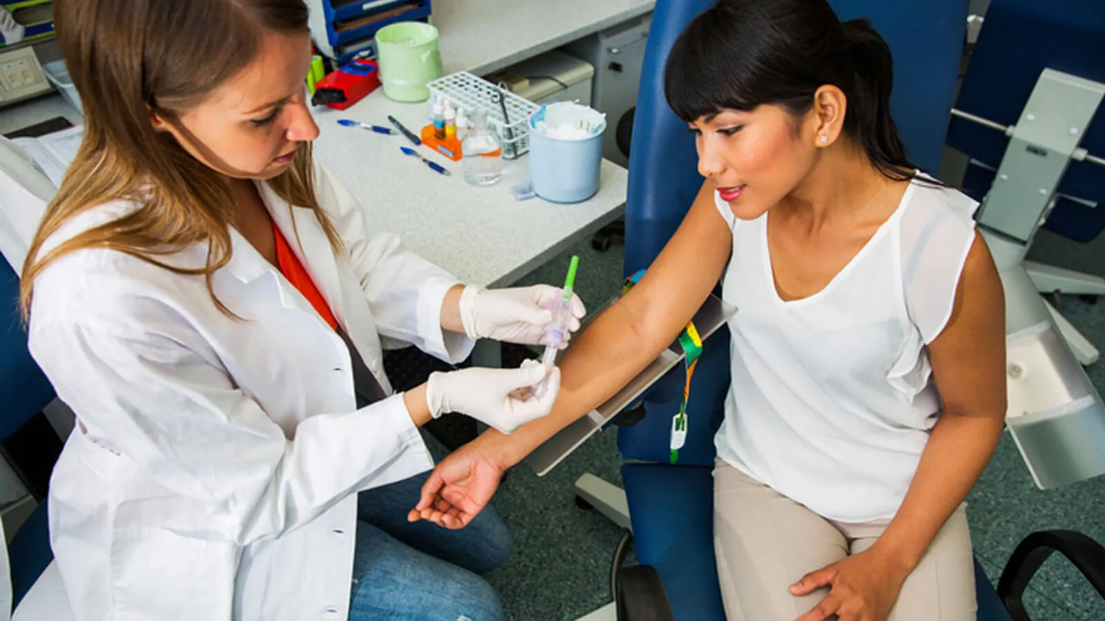 Drawing blood, young doctor preparing for blood capture