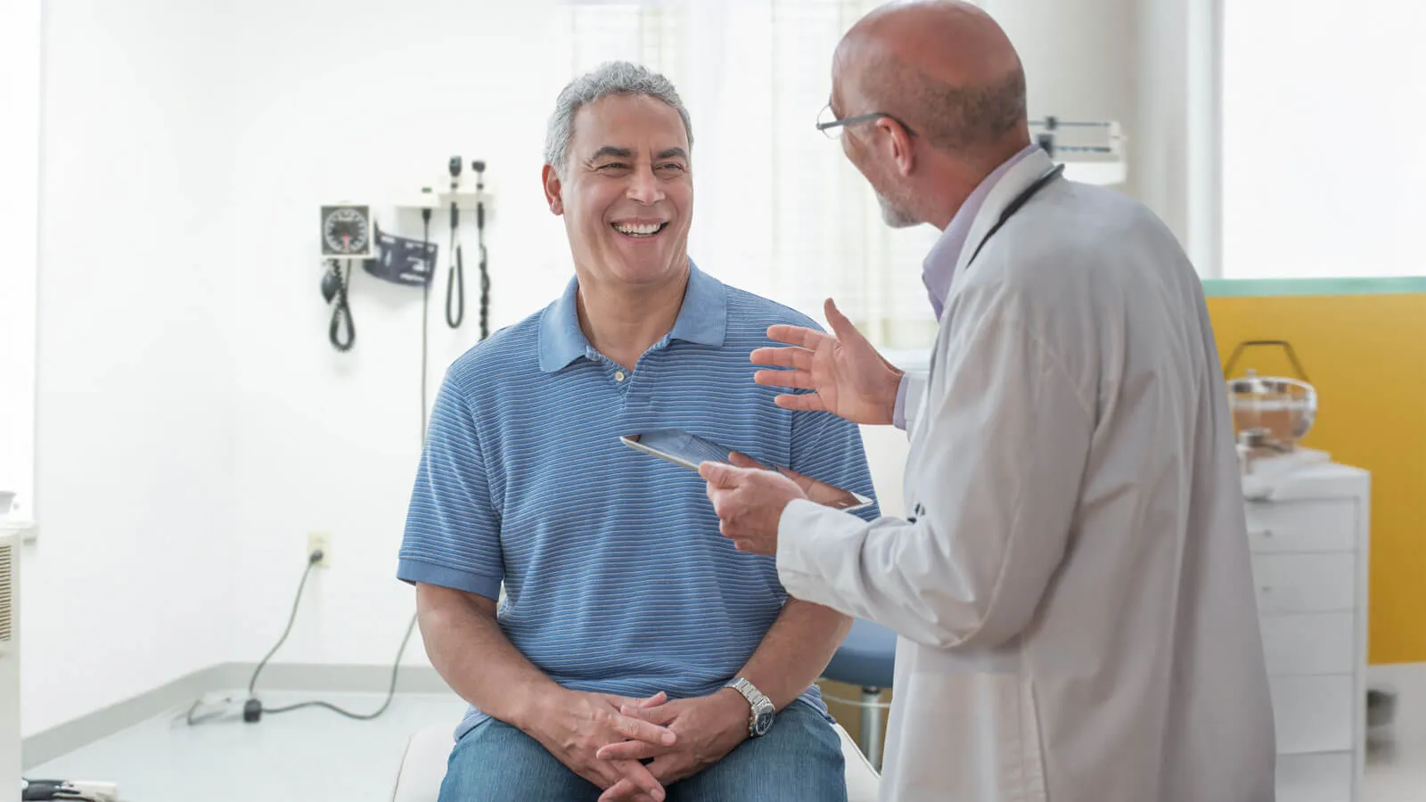 Patient smiling while talking to a doctor in an examination room