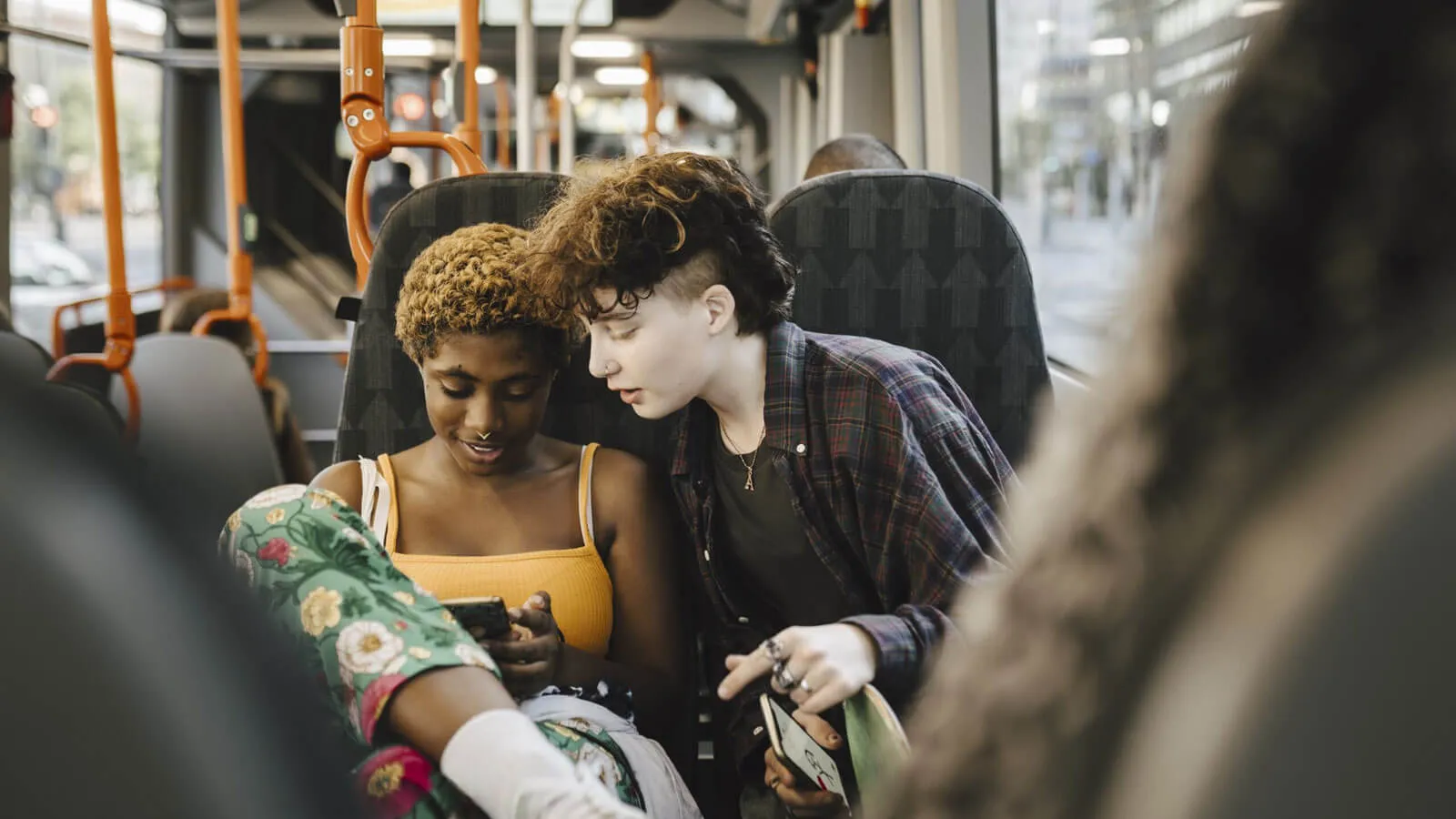 Teens on a bus looking at smartphone