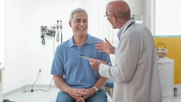 Patient smiling while talking to a doctor in an examination room