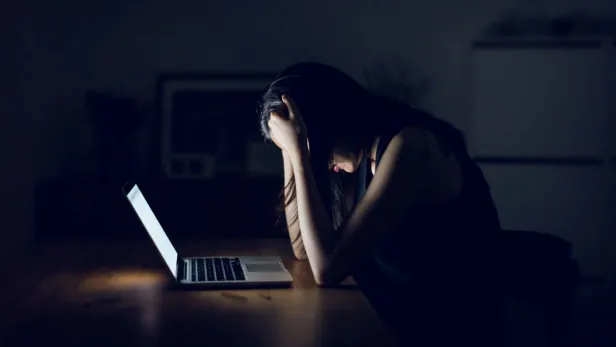 Stressed and frustrated businesswoman working till late at work